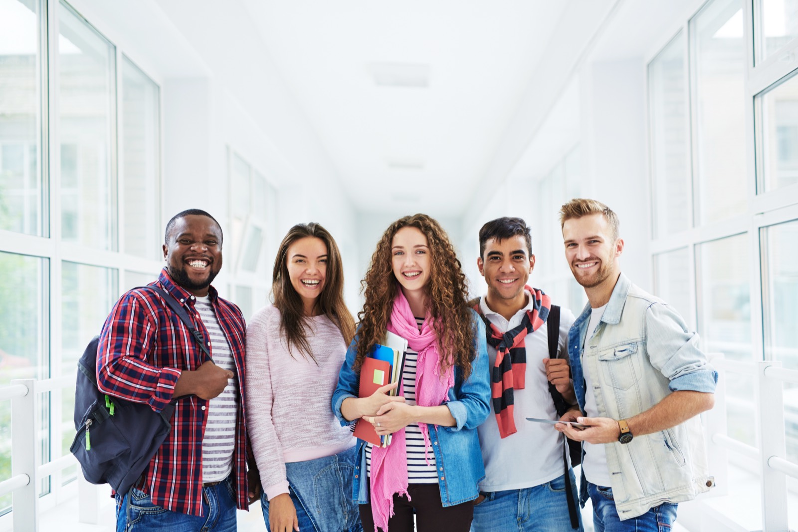 Five students standing together in a bright school hallway
