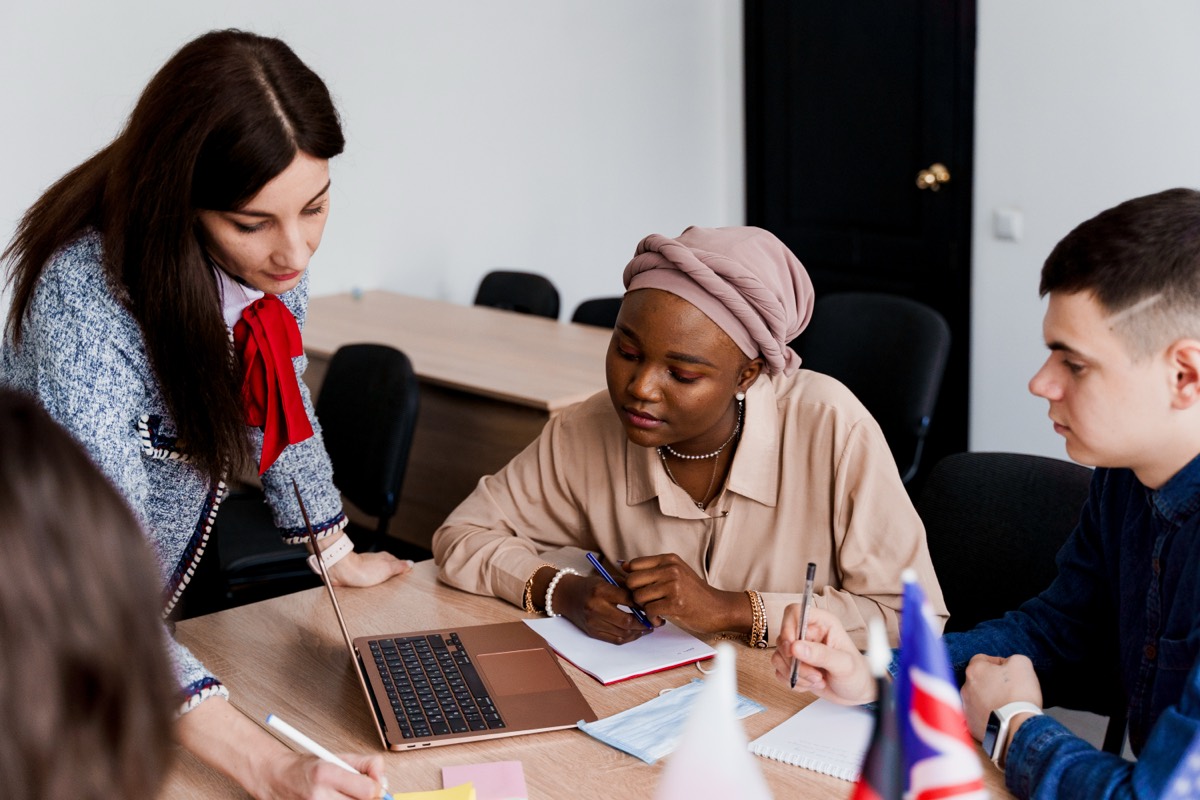 A mentor guiding two students through their coursework