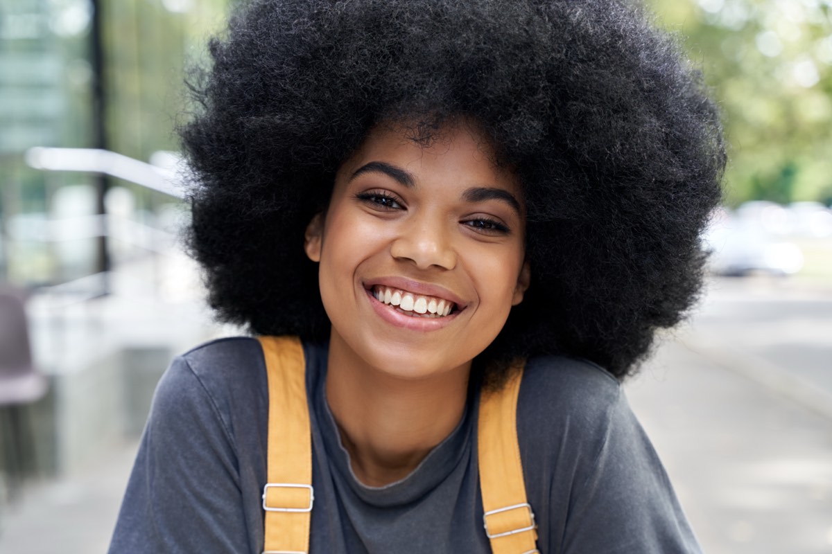 A student smiling outside her school